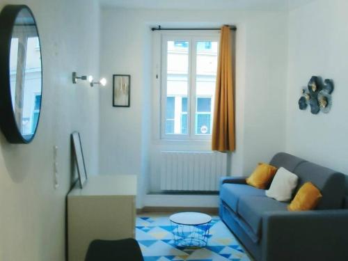a living room with a blue couch and a window at Le Cocon de Sisteron in Sisteron