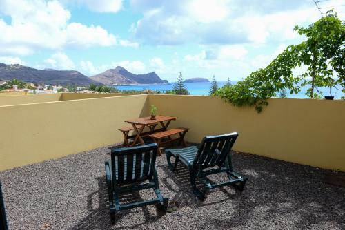 two chairs and a table on a patio with a table at Bela Vista Capazi in Porto Santo