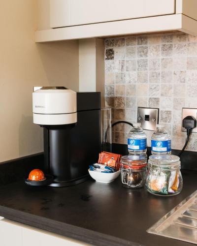 a kitchen counter with a coffee maker and jars of food at Birkby Lodge Escape in Lytham St Annes
