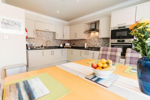Birkby Lodge Escape في ليثام سانت أنيه: مطبخ مع طاولة عليها صحن من الفواكه