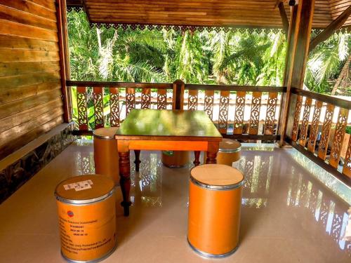 een veranda met een bank, een tafel en stoelen bij Avita Pool Villa in Sichon