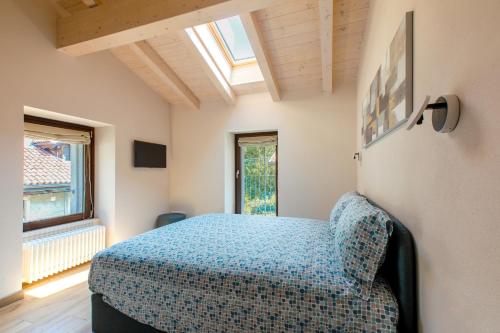 sypialnia z niebieskim łóżkiem i oknem w obiekcie Ca Vincenza in Montorfano w mieście Mergozzo