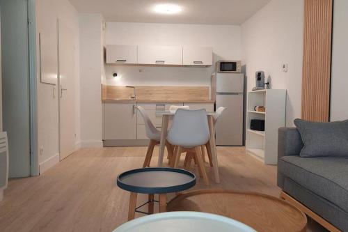un salon avec une table et des chaises et une cuisine dans l'établissement Appartement terrasse à Sarlat, à Sarlat-la-Canéda
