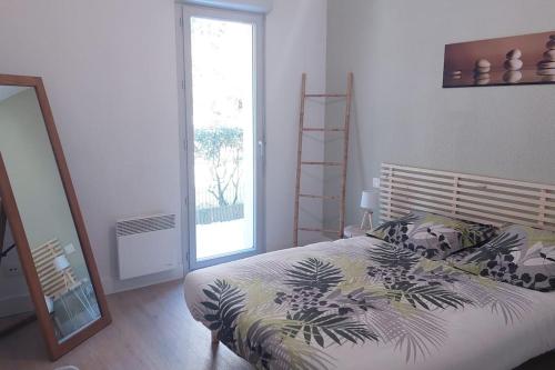 une chambre avec un lit et une grande fenêtre dans l'établissement Appartement terrasse à Sarlat, à Sarlat-la-Canéda