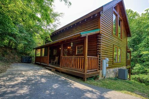 a log cabin in the woods with a driveway at Camelot #266 in Pigeon Forge