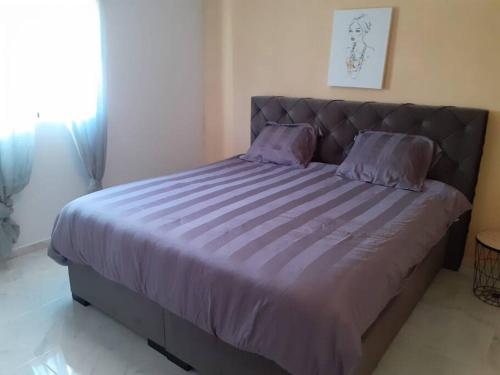 Una cama con sábanas y almohadas moradas en un dormitorio. en Casa La Vista, en Albatera