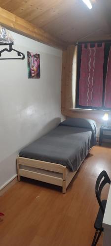 een kleine slaapkamer met een bed in een kamer bij Mansarda Nizza Tre in Turijn