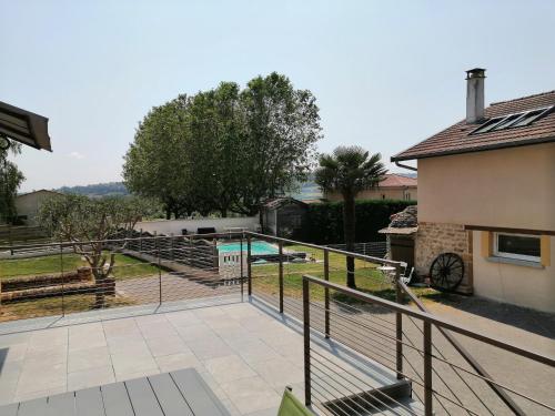 a view from the balcony of a house with a swimming pool at Gîte des Pierres Dorées in Saint-Germain-Nuelles