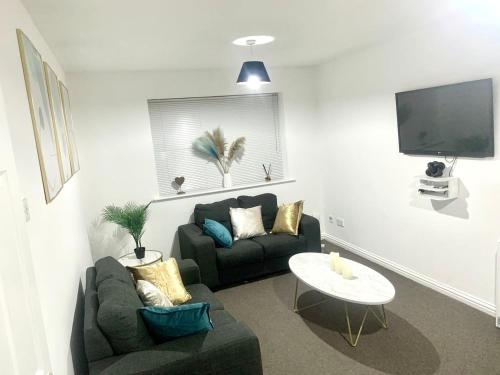 a living room with a couch and a table at Flat in London- Modern 2 Bedroom Apartment Harrow near Wembley in Harrow