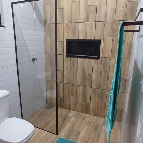 a shower with a toilet and a television on the wall at Apê Estúdio Rodrigues 02 in Paranaíba