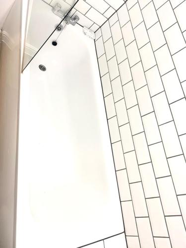 a shower with white tiled walls and a window at Flat in London- Modern 2 Bedroom Apartment Harrow near Wembley in Harrow