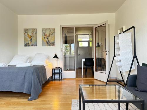 a living room with a bed and a glass table at Studio Apartment Glostrup in Glostrup