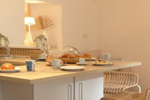 - une cuisine avec une table et du pain dans l'établissement Maison de charme sur les quais port de St Goustan, à Auray