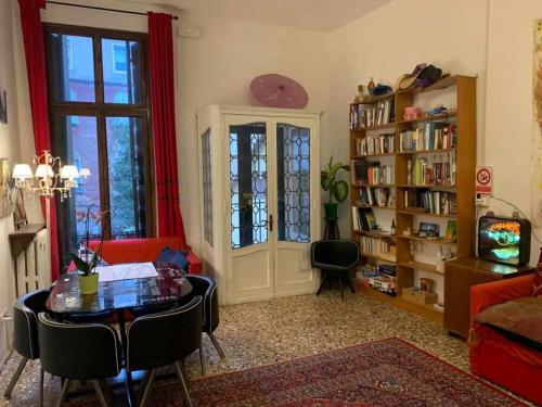 una sala de estar con una mesa y un estante de libros en VENEZIA NATURALMENTE ideale per gruppi e famiglie, en Venecia
