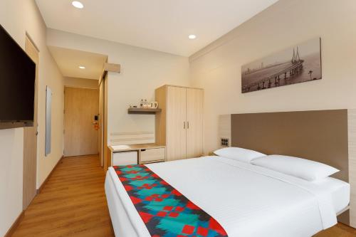 a bedroom with a large white bed and a television at Ginger Mumbai, Andheri in Mumbai