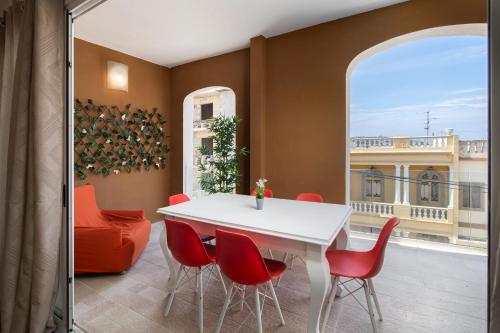 Spacious Luxury 3BR Apartment with Terrace & Open Views - Zurrieq, close to sea في Żurrieq: غرفة طعام مع طاولة بيضاء وكراسي حمراء