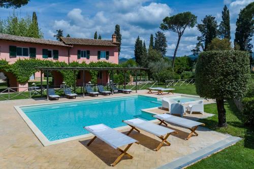 a pool with lounge chairs and a house at Le Versegge Resort in Braccagni