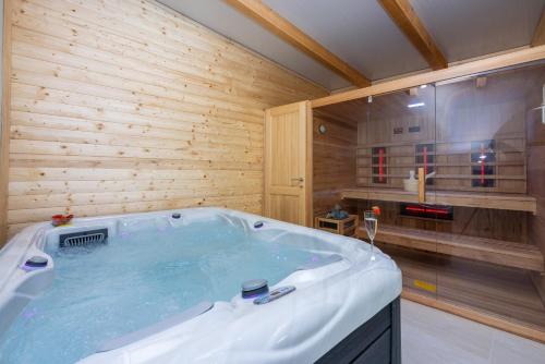 a jacuzzi tub in a room with wooden walls at Villa Antani with heated pool, sauna & jacuzzi in Crikvenica