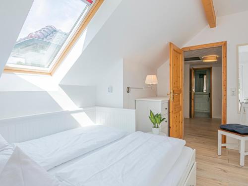 a white bedroom with a large bed and a window at Lieblingsort Freude in Timmendorfer Strand