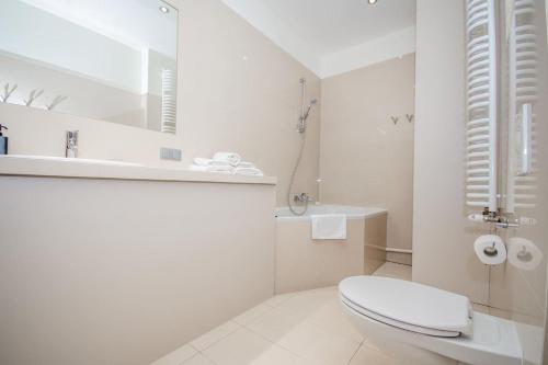 a white bathroom with a toilet and a sink at InPoint 2-bedrooms Apartment with private garden and free parking in Krakow
