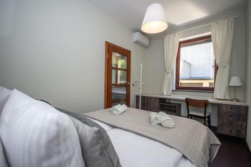 a bedroom with a bed and a desk and a window at InPoint 2-bedrooms Apartment with private garden and free parking in Krakow