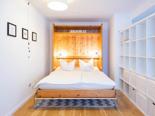 a bedroom with a bed with a wooden headboard at Lieblingsort fröhlichkeit in Timmendorfer Strand