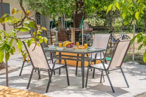 a table and chairs with a bowl of fruit on it at Ira's House in Sami