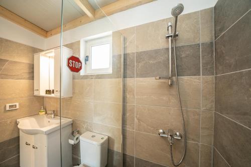een badkamer met een douche en een toilet en een stopbord bij Ira's House in Sami