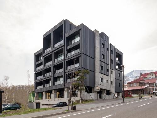 a black building on the side of a street at Suiboku in Niseko