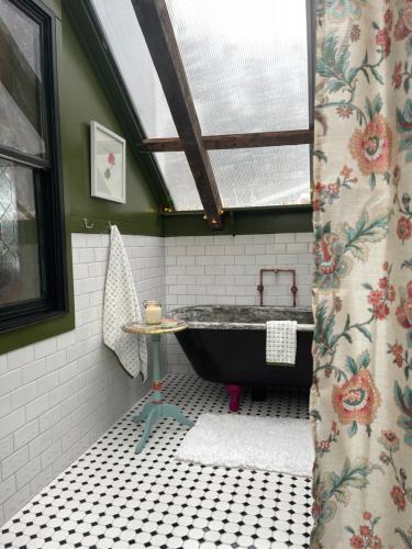 uma casa de banho com uma banheira e uma janela em The Four Pillars Farmstead 
