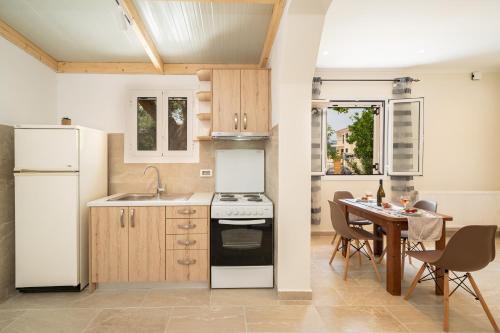 a kitchen with white appliances and a table with chairs at Ira's House in Sami