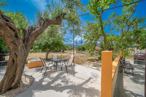 a patio with a table and chairs under a tree at Ira's House in Sami