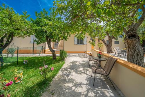 a patio with a table and chairs and trees at Ira's House in Sami