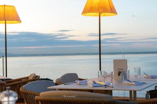 a table with chairs and a view of the ocean at Hospes Maricel y Spa, Palma de Mallorca, a Member of Design Hotels in Cas Catala