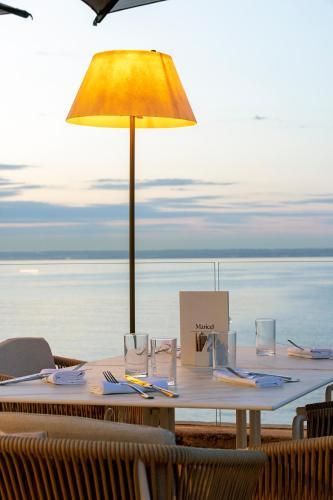 a table with a yellow umbrella on the beach at Hospes Maricel y Spa, Palma de Mallorca, a Member of Design Hotels in Cas Catala