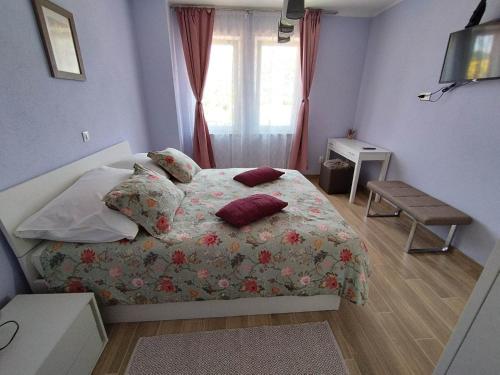 a bedroom with a bed with pillows and a window at Panoramic View Apartment Leonardo in Rab