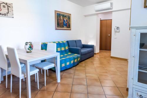 uma sala de estar com um sofá, uma mesa e cadeiras em SE014 - Senigallia, nuovo bilocale comodo a centro e spiaggia em Senigallia