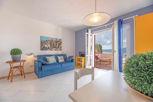 un soggiorno con divano blu e tavolo di Apartments La Turistica a Capoliveri