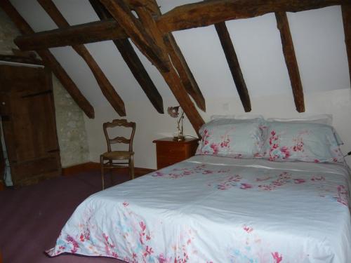 a bedroom with a white bed with pink flowers on it at luxury cottage for 2, beautiful views, large swimming pool, no children in Issigeac