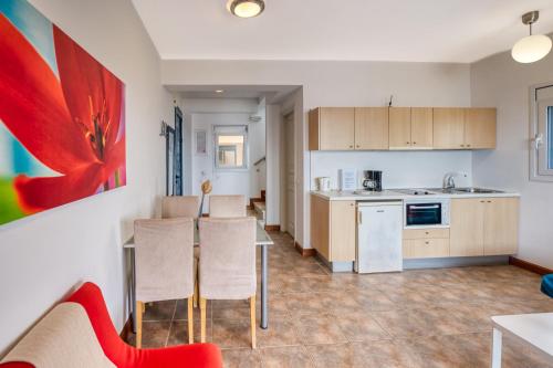 a kitchen and living room with a table and chairs at Glyfa Corfu Apartments in Barbati