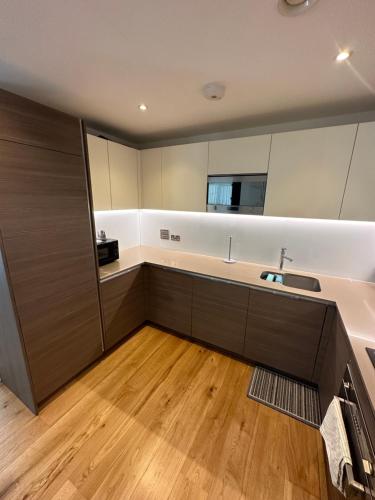a kitchen with a sink and a large mirror at Colindale luxury Apartment in Colindale