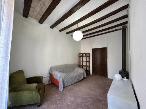 Habitación con cama, sofá y silla en Can Pacoli, en Rupià