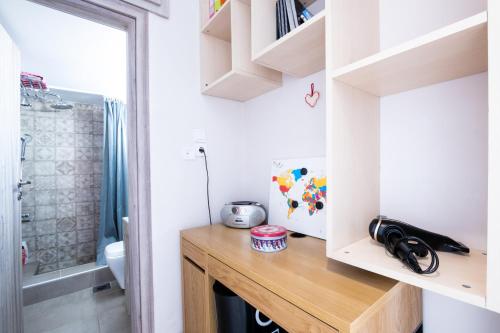 a small bathroom with a wooden desk and a shower at Family Apartment near Port in Piraeus
