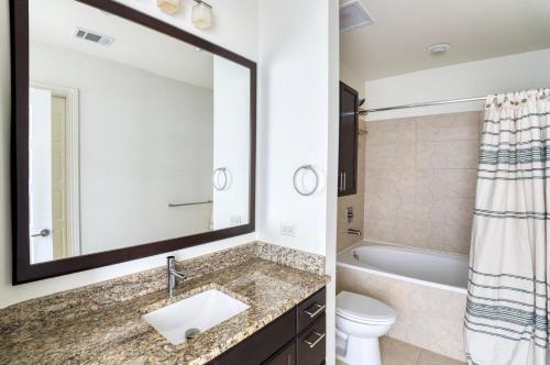 a bathroom with a sink and a toilet and a mirror at Downtown Austin 1br w gym pool wd nr Capitol ATX-165 in Austin