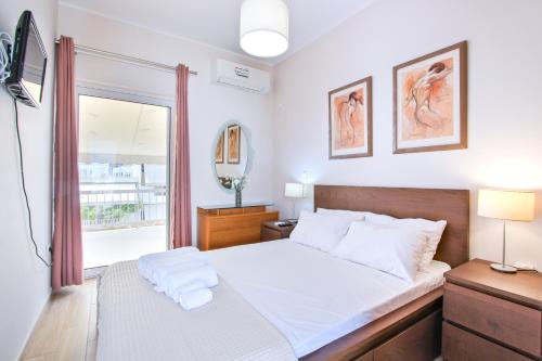 a bedroom with a white bed and a window at Family Apartment near Port in Piraeus