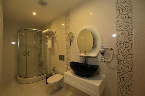 y baño con lavabo, aseo y ducha. en Grand Harsena Otel, en Amasya