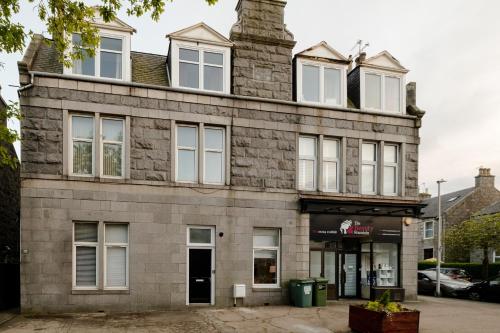an old stone building with white windows on a street at West End Retreat - SJA Stays - 2 Bed Apartment in Aberdeen