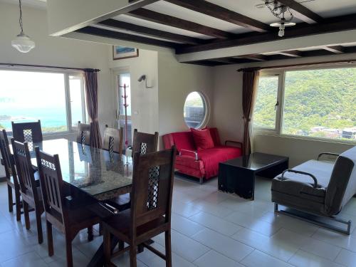 a dining room with a table and chairs and a couch at Slowly B&B in Jiufen