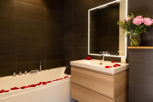 a bathroom with a sink and a bath tub with roses at Les Sarments in Santenay