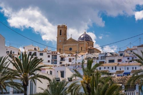 a building with a clock tower on top of a city at Casa Violeta in Altea